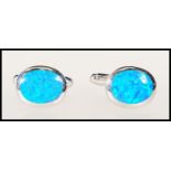 A pair of silver stamped 925 gentleman's cufflinks of oval form set with blue opals panels. Gross