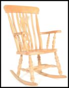 An antique style beech wood Windsor style lathe back rocking chair. Raised on turned legs on