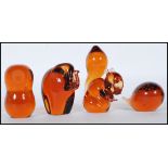 A group of four vintage 20th Century Wedgwood studio glass amber glass paperweights in the form of