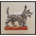 A stamped sterling silver brooch in the form of a West Highland Terrier set with a ruby eye standing