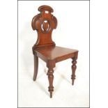 A 19th Century Victorian mahogany hall chair raised on turned legs with C scroll back and armorial