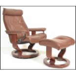 A retro 20th Century style tan / brown leather reclining swivel easy chair in the manner of Ekornes,