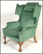 A good quality 20th century large wingback armchair raised on cabriole legs with claw and ball feet.