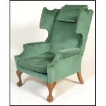 A good quality 20th century large wingback armchair raised on cabriole legs with claw and ball feet.