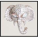 A stamped 925 silver ring in the form of an elephants head set with Cz's and opal eyes. Ring size P.