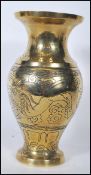 A Chinese polished bronze vase of bulbous form, chase decorated with a dragon spitting fire within