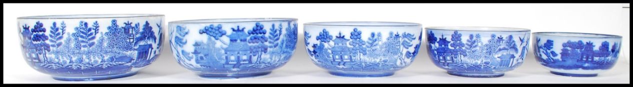 A set of five early 20th Century graduating blue and white Willow pattern serving bowls by