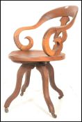 A 19th Century Victorian walnut captains swivel desk chair, scroll shaped armrests and back with