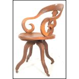 A 19th Century Victorian walnut captains swivel desk chair, scroll shaped armrests and back with
