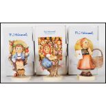 A group of three German Goebel Hummel figurines in boxes to include Herbet Apple tree boy,