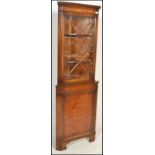 An Old English style walnut freestanding corner cupboard, the lower section with burr walnut panel