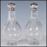 A pair of 19th Century Victorian silver hallmarked salt and pepper condiments having crystal glass