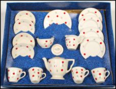 A mid 20th Century child's decorated pottery tea service by Ellar, four cups with saucers, side