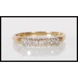 An English hallmarked 9ct gold ring set with a row of seven round cut diamonds. Assay marked