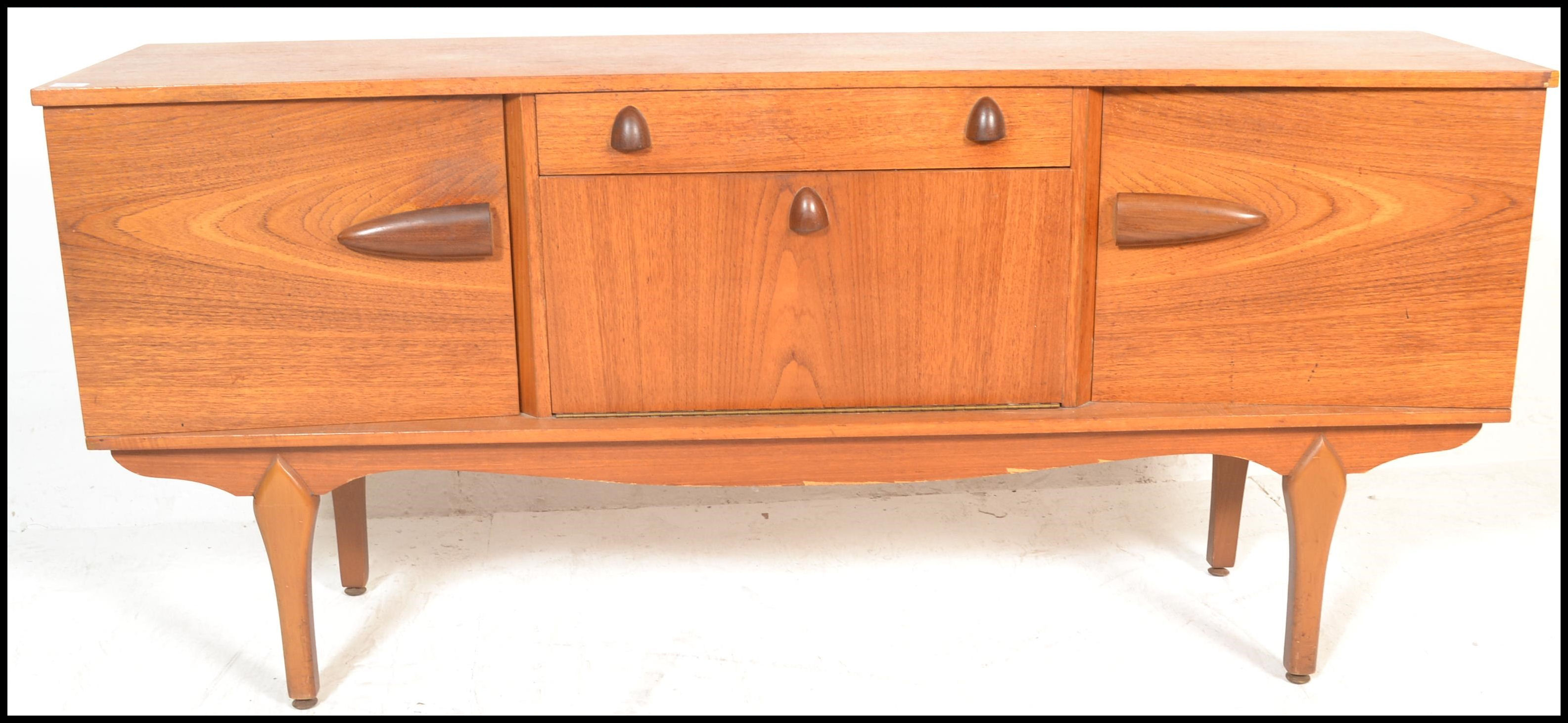 A vintage mid 20th century teak wood sideboard having a central drop down bar compartment with - Image 2 of 6