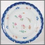 An 18th Century Chinese porcelain plate having a scalloped rim with blue and white painted