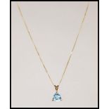A 9ct gold fine lined ladies necklace chain set with a 9ct gold blue quartz pendant drop. Measures