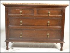 An early 20th Century Jacobean revival oak chest of drawers having a configuration of two short