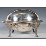A silver plate bacon / kipper warmer raised on four legs with lion head masks and hairy paw feet,