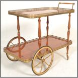 A vintage retro two tier Italian style drinks trolley, brass pierced gallery surround to each tier