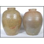 A pair of early 20th Century large floor standing stoneware pickle / olive jars of conical form with