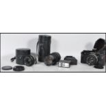 A vintage Olympus OM-2N film camera with a 1:1.8 f=50mm lens along with two more lenses, an