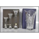 A boxed set of three Xavier Crystal candlesticks of graduating form having shaped rounded tops and