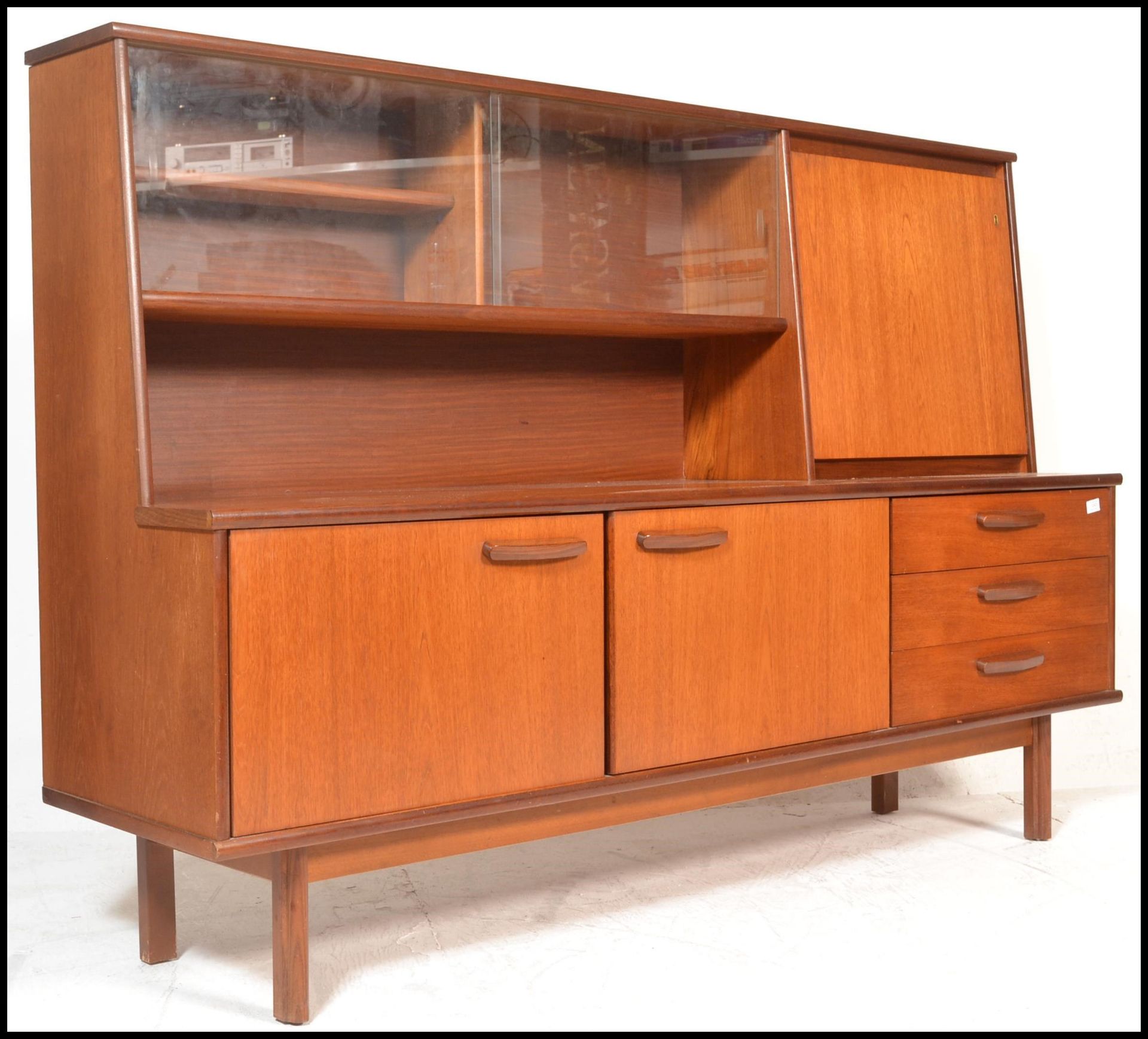 A retro 20th Century teak wood highboard sideboard credenza, being raised on square supports