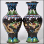 A matching pair of early 20th Century Chinese cloisonne enamel black ground vases of baluster form
