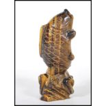A 20th Century Chinese carved tigers eye ornament in the form of a koi carp fish jumping from the
