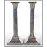 A pair of early 20th Century Edwardian silver plate Corinthian column candlesticks, each with