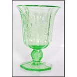 An early 20th Century Art Deco pressed green glass footed vase of octagonal form having raised