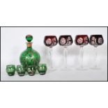 A believed 19th century Loetz manner silver overlay green glass Bohemian decanter and shot glass set