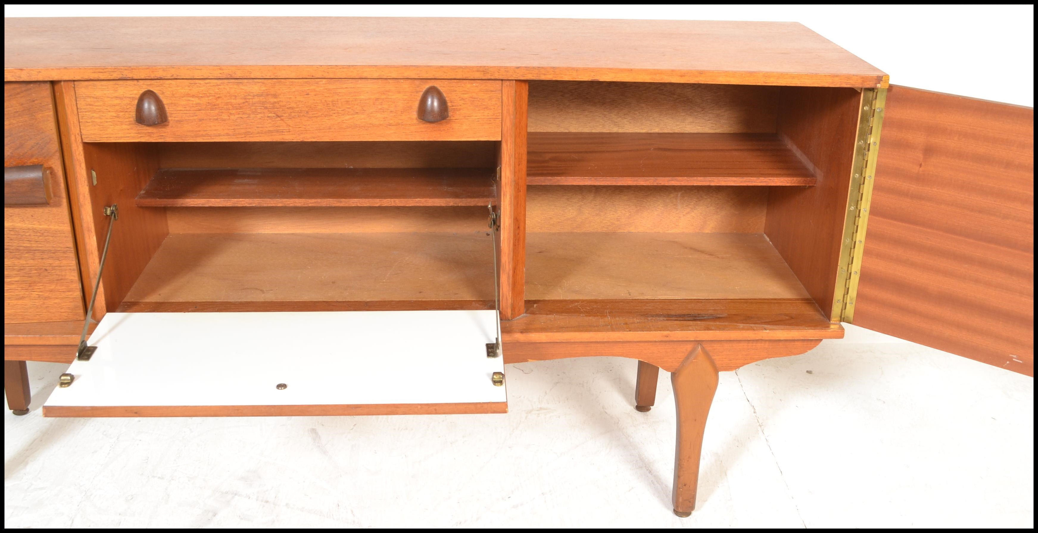 A vintage mid 20th century teak wood sideboard having a central drop down bar compartment with - Image 5 of 6