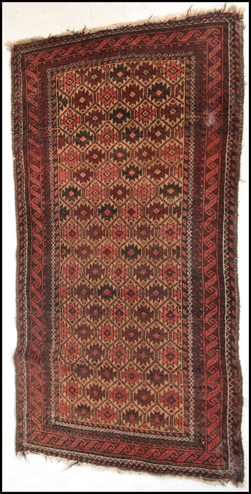 A 20th Century woolen hand knotted carpet floor rug on red ground, central geometric panel