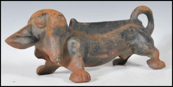 An early 20th Century cast iron boot scraper scrape in the form of a Dachshund dog. Measures 11 cm