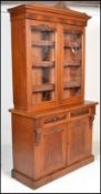 A Victorian 19th century walnut library bookcase cabinet. Raised on a plinth base with short drawers