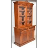 A Victorian 19th century walnut library bookcase cabinet. Raised on a plinth base with short drawers