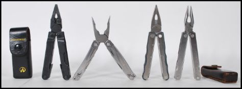 A group of four Leatherman USA pocket tools. Two in original leather case with each one being a