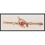 A 19th Century Victorian brooch stamped 9ct gold moulded as a wishbone set with a central faceted