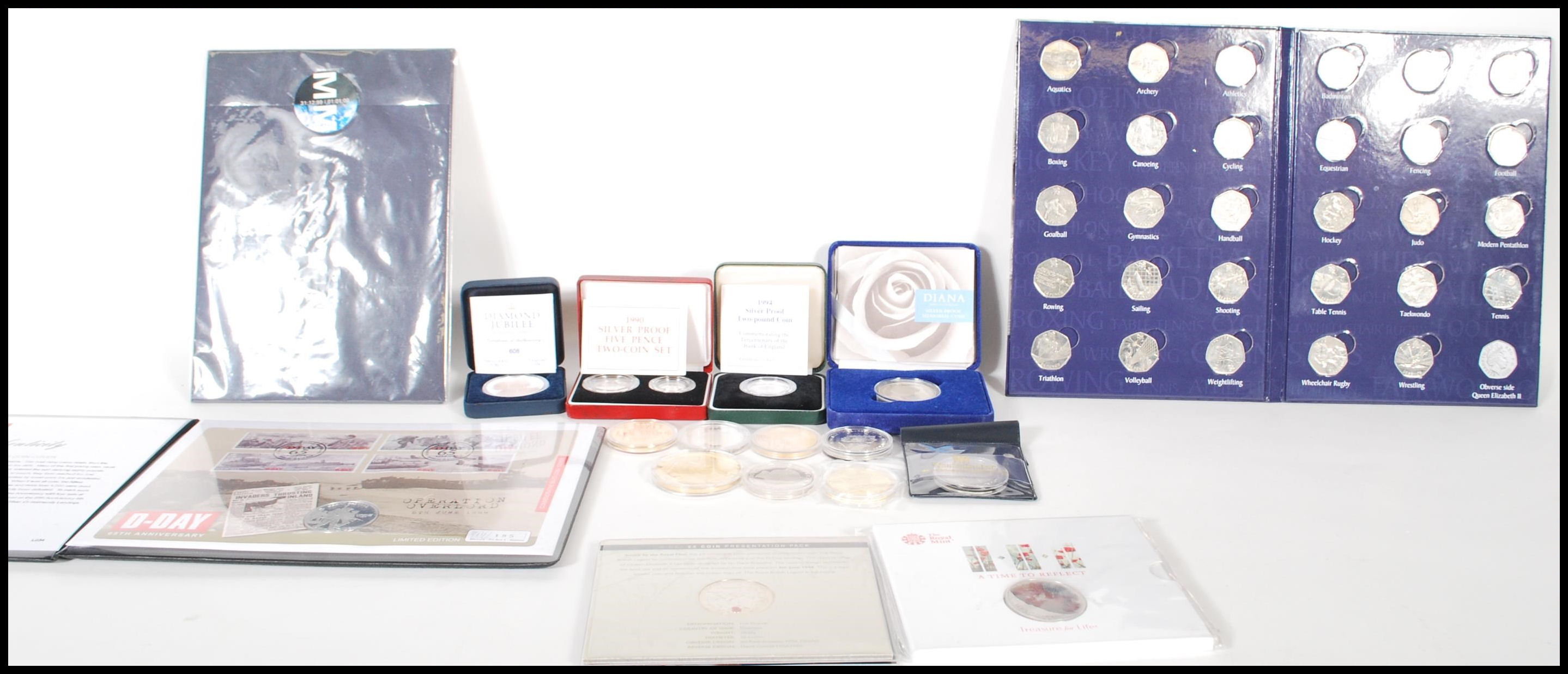 A collection of commemorative coins and silver proof coins to include D-Day £5 Coin Presentation