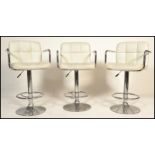 A set of three vintage 20th century adjustable bar stools raised on central chromed columns