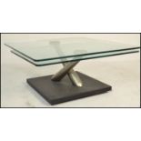 A contemporary  Naos coffee break glass swivel topped designer low table, stainless steel supports