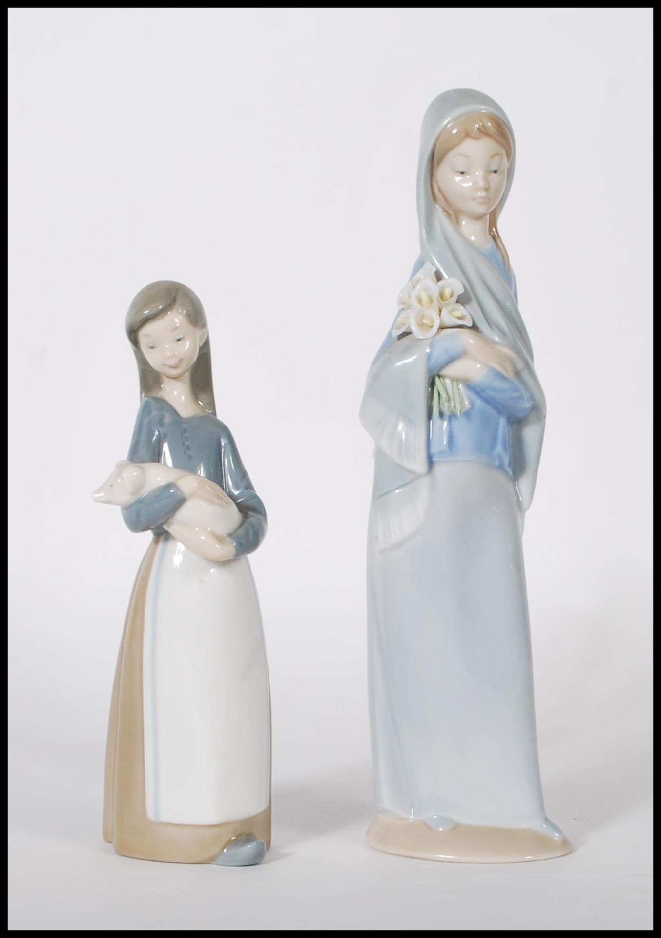 Lladro - A pair of 20th Century porcelain ceramic figurines comprising: 4650 Girl with Calla