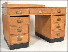 A 1930's Art Deco oak twin pedestal office desk. Raised on ebonised plinths with banks of drawers to