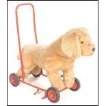 A vintage 1950's push / ride along upholstered Airedale terrier dog fixed to a tubular red painted