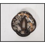 An antique style bronze Japanese tsuba decorated with birds and flowers finished in a gold and