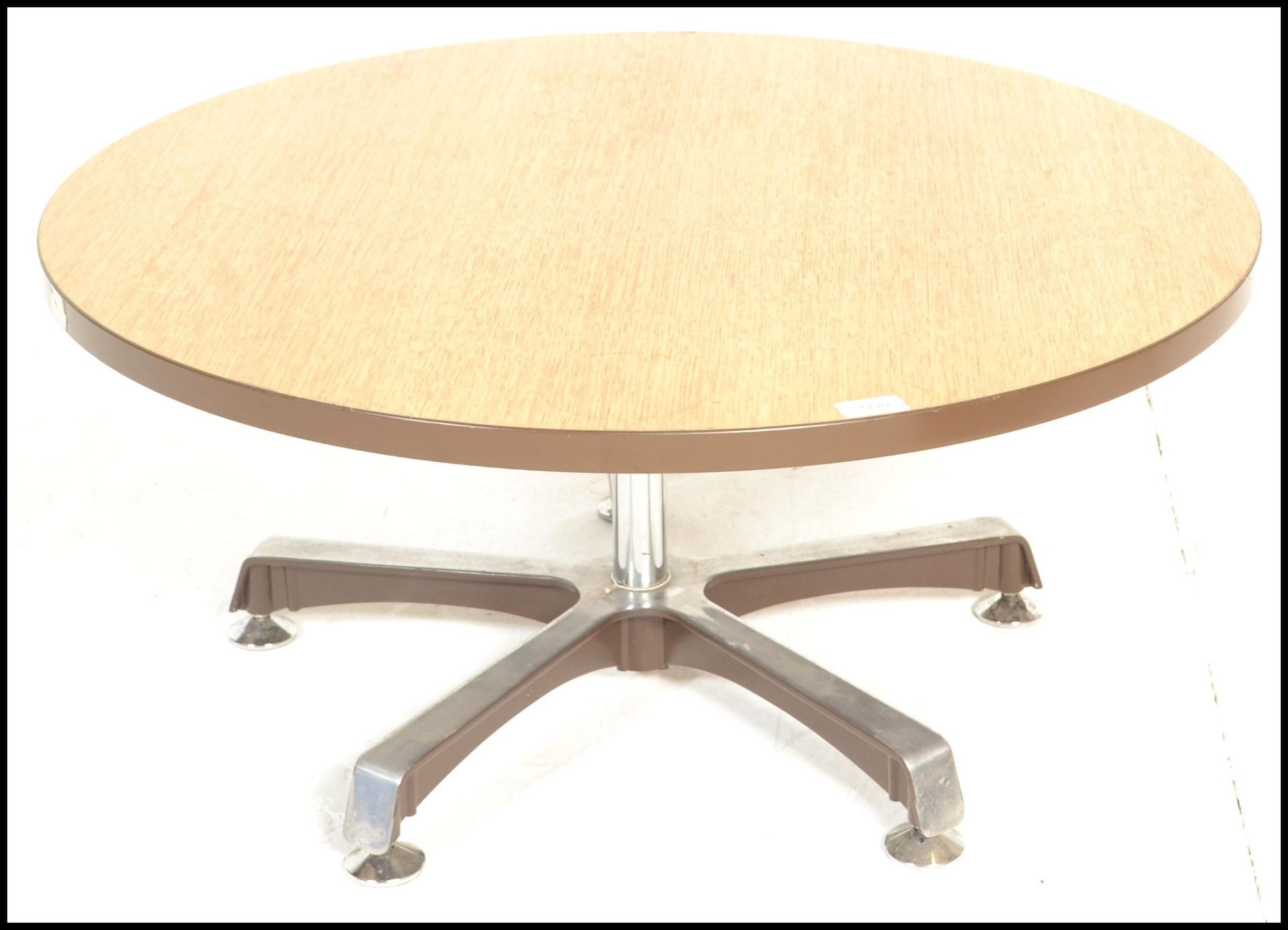 A retro 20th Century oak topped round coffee table raised on a single metal pedestal, supported by