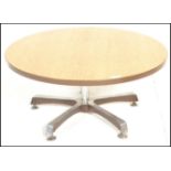 A retro 20th Century oak topped round coffee table raised on a single metal pedestal, supported by
