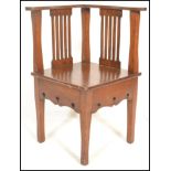 A late 19th Century  early 20th Century oak Arts and Crafts corner chair, pierced splat backs with